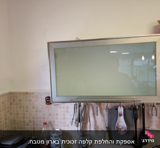 ארון זכוכית במטבח עם כלים תלויים